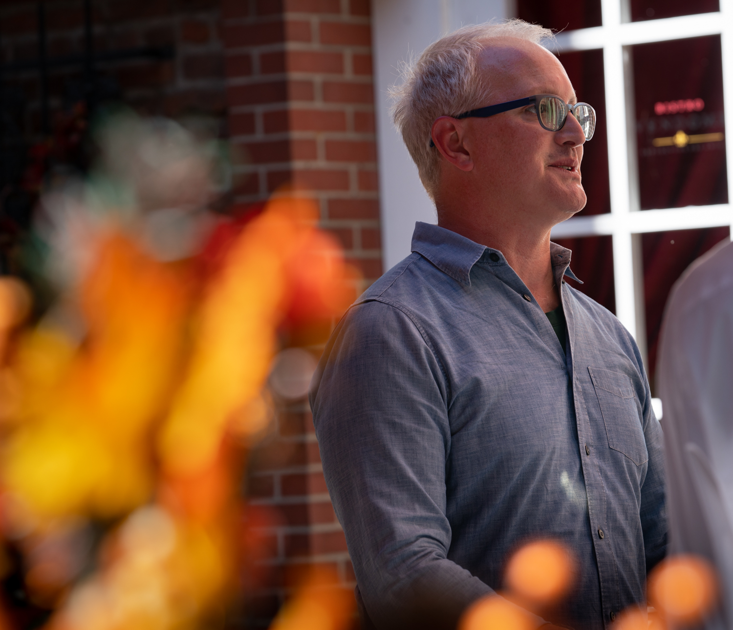 Vinmarket – man with glasses behind leaves